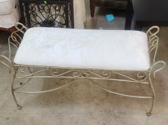 Beautiful and ornate bench featuring a lightly distressed paint finish and a comfortable seat.