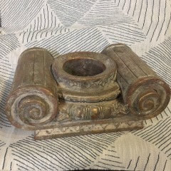 column capital or pillar base, decorative element, or candle holder.