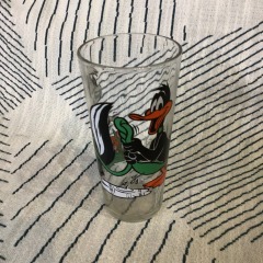 vintage 1976 Pepsi Collector Series drinking glass featuring Looney Tunes characters Daffy Duck and Pepe Le Pew.