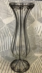 vintage hand-blown caged glass vase featuring a wrought iron filigree frame.