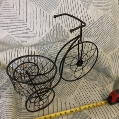 Tricycle plant stand features a classic black finish with a circular planter basket