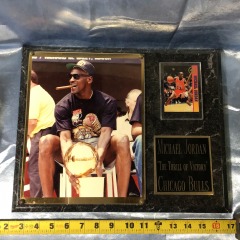 1991 championship photograph of Michael Jordan holding the Larry O'Brien Trophy, paired with a 1999 Upper Deck trading card. \
