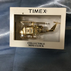 Vintage Timex collectible mini-clock shaped like a helicopter, featuring a polished gold-tone finish