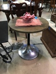 CB2 Hackney Wood Bistro Table featuring a dark wood top and a tri-metal pedestal base